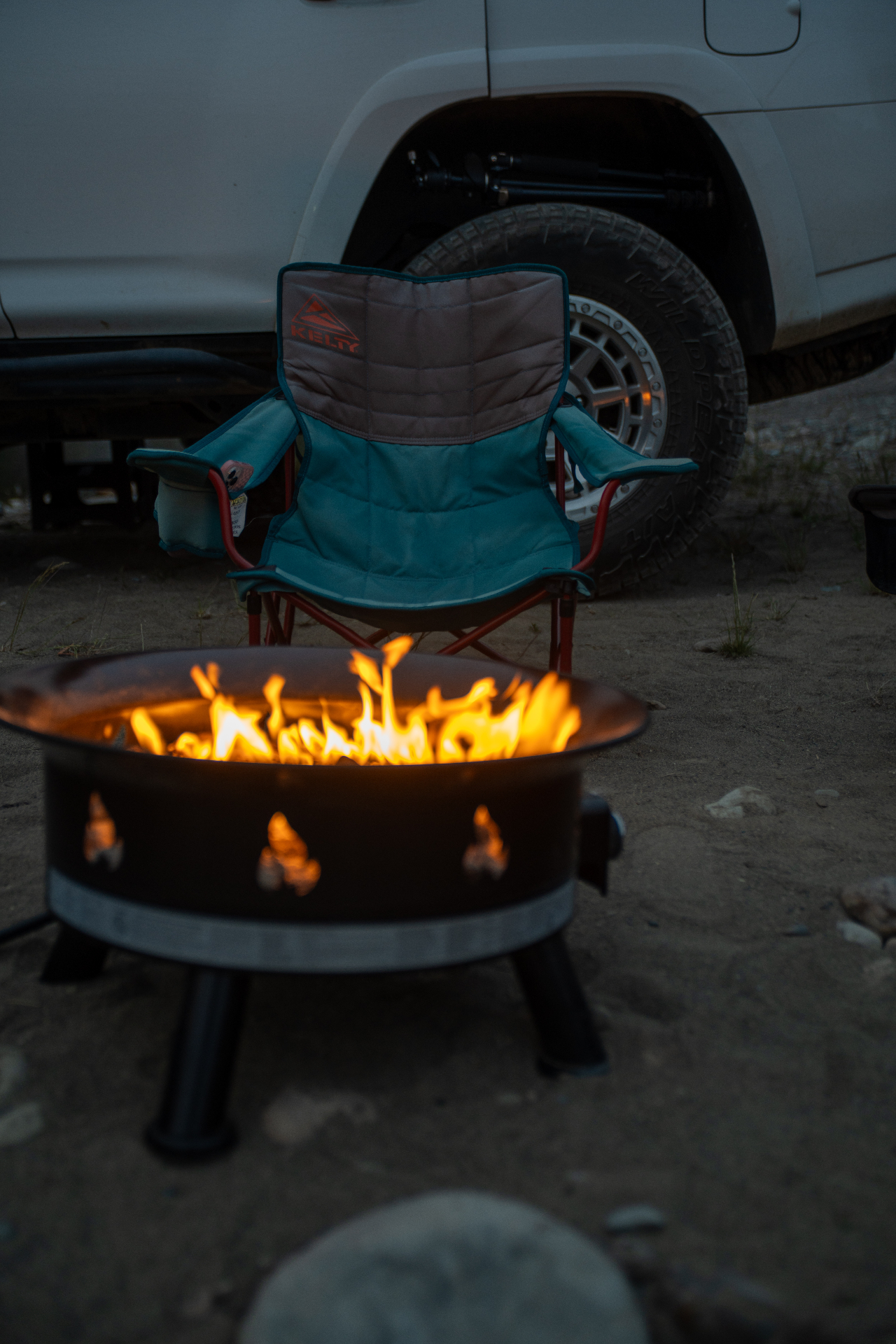 Camp chair beside fire pit at dusk with 4Runner in background
