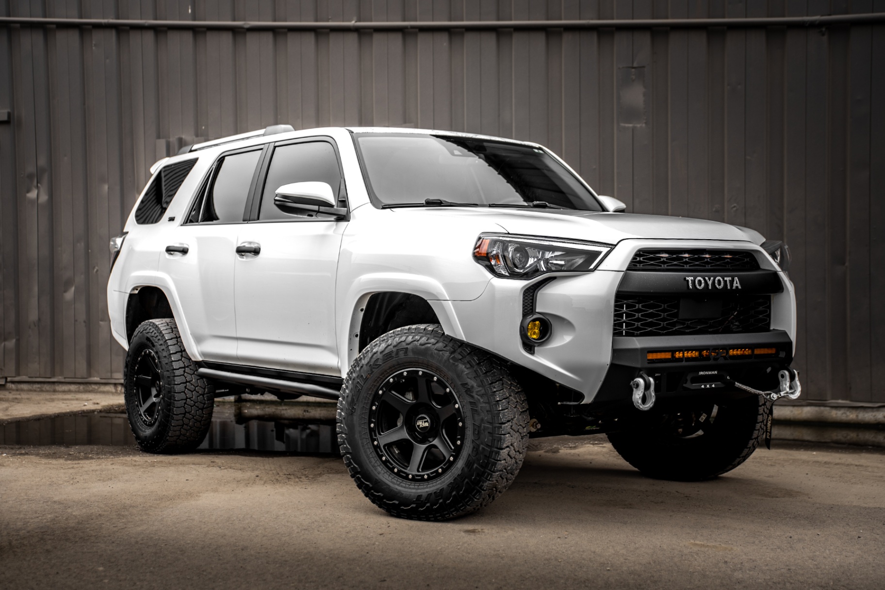 Studio-style outdoor vehicle portrait against industrial wall