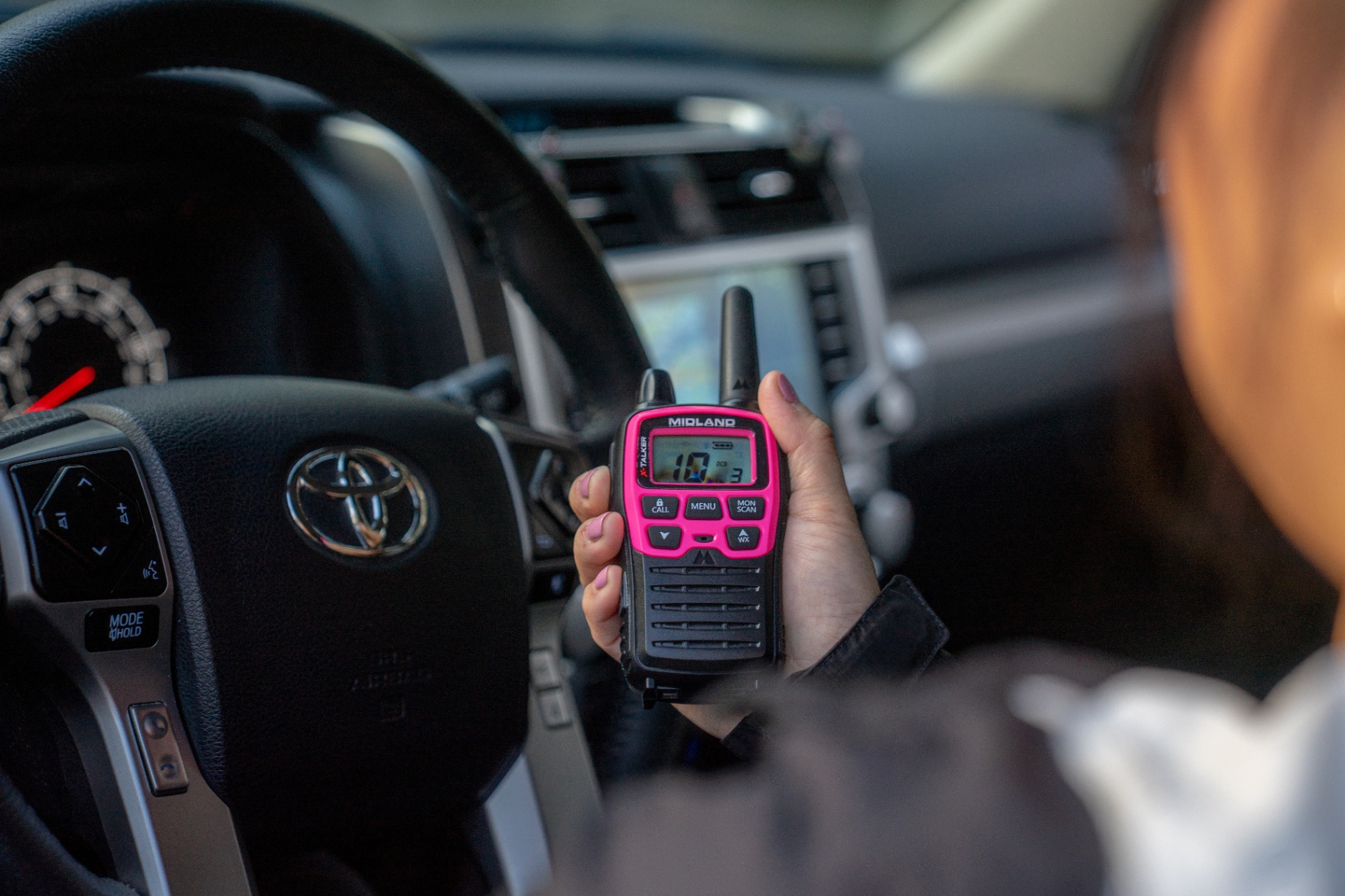 Pink Midland X-Talker radio held inside a Toyota cabin