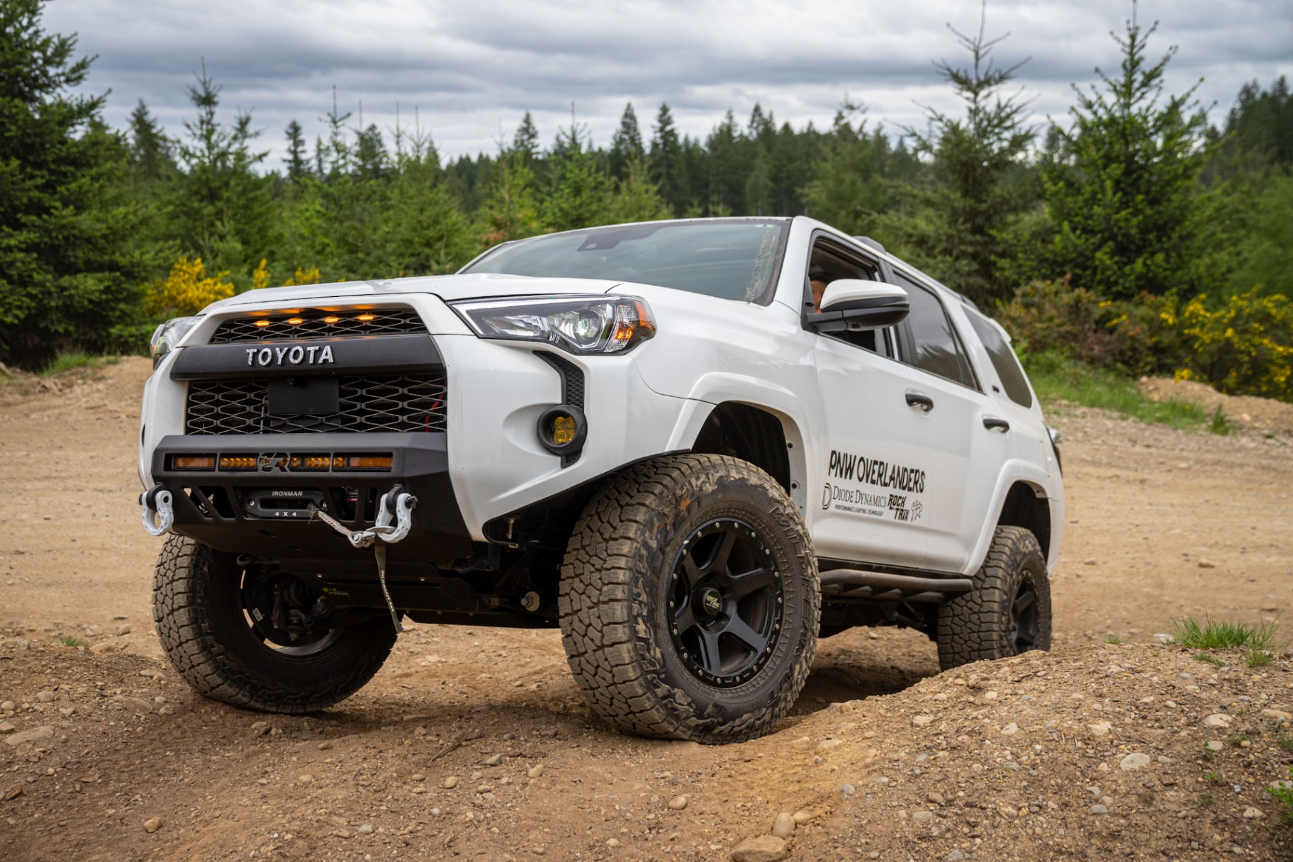White 4Runner with Cali Raised LED bumper and lights on a dirt road